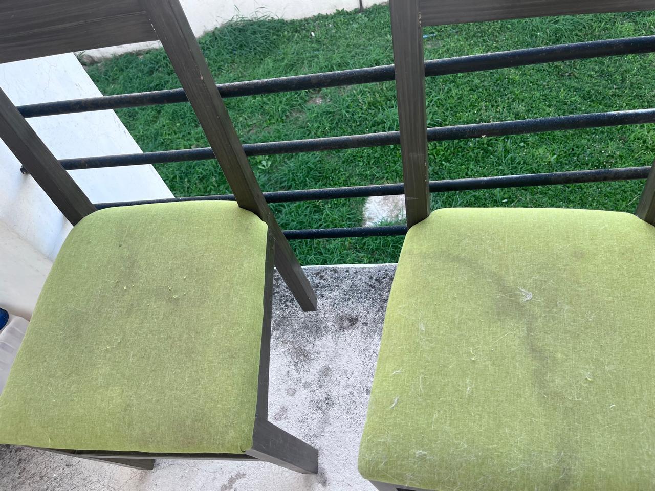 Dos sillas con asientos verdes, una con manchas visibles.